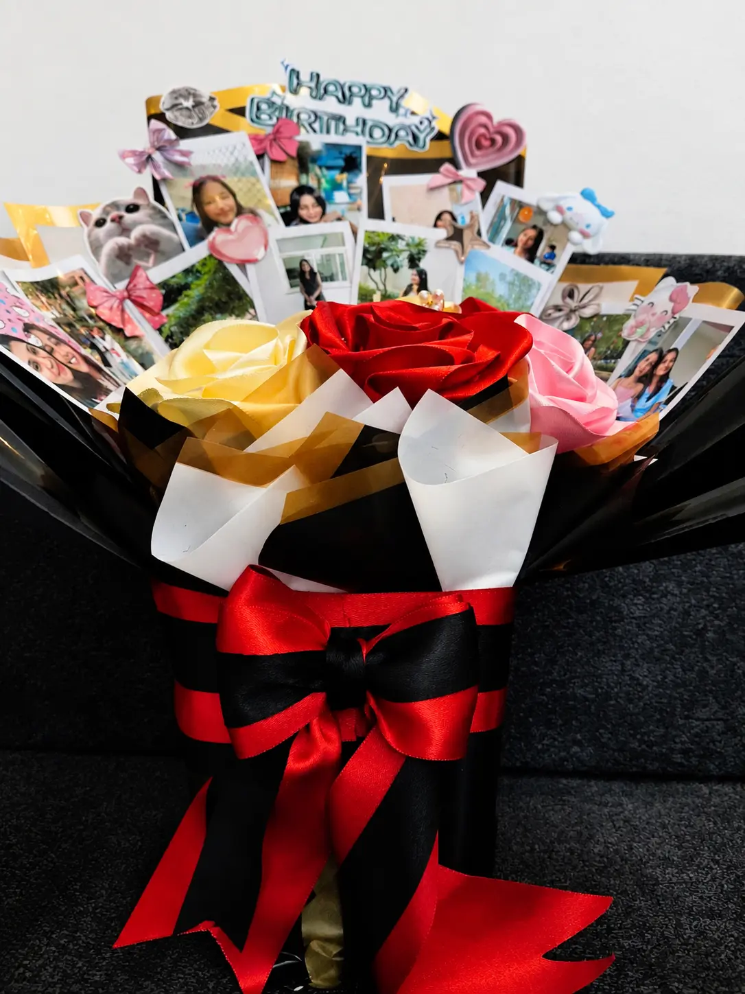 Birthday bouquet with satin roses, personal photographs and a red bow